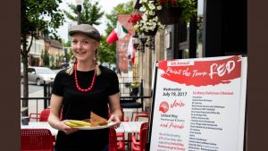 Sam Sayer of Sam's Place, holds her "Paint the Town Red" sandwich which will be available all day July 19th for the event!